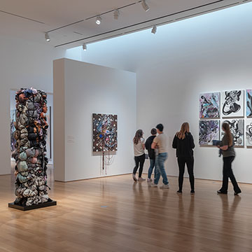 A group of 5 people view works by Shinique Smith at her Stargazers exhibition at the Nerman